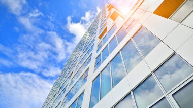 Çok katlı, modern bir apartmanın dış cephesi, pencereleri ve balkonları..