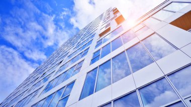 Çok katlı, modern bir apartmanın dış cephesi, pencereleri ve balkonları..