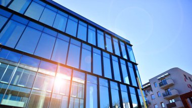 Yeni modern ofis binasının yanında camdan yüzlü modern bir apartman manzarası..