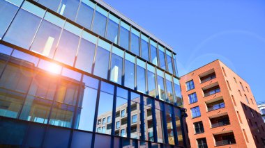 Yeni modern ofis binasının yanında camdan yüzlü modern bir apartman manzarası..