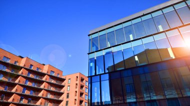 Yeni modern ofis binasının yanında camdan yüzlü modern bir apartman manzarası..