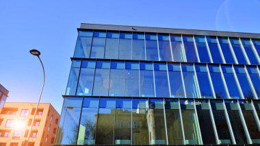 Yeni modern ofis binasının yanında camdan yüzlü modern bir apartman manzarası..