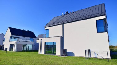 Yeni zarif, modern bekar aile evi. Yeni geliştirilmiş konutlarda teraslı aile evleri. Beyaz duvarları olan modern bir evin cephesi. Emlak konsepti, Avrupa tarzı.  