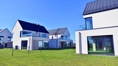 Yeni zarif, modern bekar aile evi. Yeni geliştirilmiş konutlarda teraslı aile evleri. Beyaz duvarları olan modern bir evin cephesi. Emlak konsepti, Avrupa tarzı.  