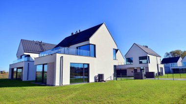 Yeni zarif, modern bekar aile evi. Yeni geliştirilmiş konutlarda teraslı aile evleri. Beyaz duvarları olan modern bir evin cephesi. Emlak konsepti, Avrupa tarzı.  