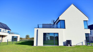 Yeni zarif, modern bekar aile evi. Yeni geliştirilmiş konutlarda teraslı aile evleri. Beyaz duvarları olan modern bir evin cephesi. Emlak konsepti, Avrupa tarzı.  