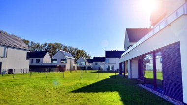 Yeni zarif, modern bekar aile evi. Yeni geliştirilmiş konutlarda teraslı aile evleri. Beyaz duvarları olan modern bir evin cephesi. Emlak konsepti, Avrupa tarzı.  