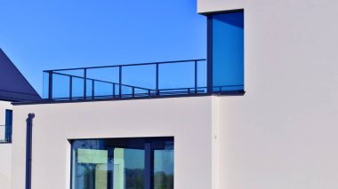 Yeni zarif, modern bekar aile evi. Yeni geliştirilmiş konutlarda teraslı aile evleri. Beyaz duvarları olan modern bir evin cephesi. Emlak konsepti, Avrupa tarzı.  