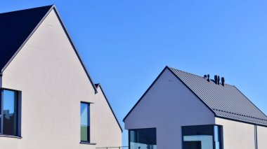 Yeni zarif, modern bekar aile evi. Yeni geliştirilmiş konutlarda teraslı aile evleri. Beyaz duvarları olan modern bir evin cephesi. Emlak konsepti, Avrupa tarzı.  