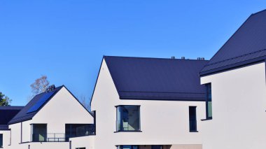 Yeni zarif, modern bekar aile evi. Yeni geliştirilmiş konutlarda teraslı aile evleri. Beyaz duvarları olan modern bir evin cephesi. Emlak konsepti, Avrupa tarzı.  