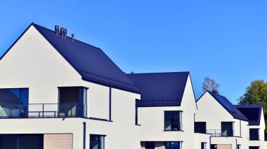 Yeni zarif, modern bekar aile evi. Yeni geliştirilmiş konutlarda teraslı aile evleri. Beyaz duvarları olan modern bir evin cephesi. Emlak konsepti, Avrupa tarzı.  