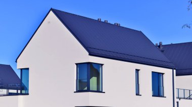 Yeni zarif, modern bekar aile evi. Yeni geliştirilmiş konutlarda teraslı aile evleri. Beyaz duvarları olan modern bir evin cephesi. Emlak konsepti, Avrupa tarzı.  