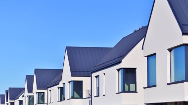 Bir yerleşim bölgesinde modern kasaba evleri olan şehir manzarası, yeşil tesisleri olan yeni apartmanlar. Küçük bir kasaba yerleşim alanı. Kenar mahallelerde sürdürülebilir yaşam alanı var.. 