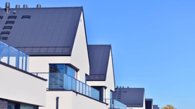 Yeni zarif, modern bekar aile evi. Yeni geliştirilmiş konutlarda teraslı aile evleri. Beyaz duvarları olan modern bir evin cephesi. Emlak konsepti, Avrupa tarzı.  