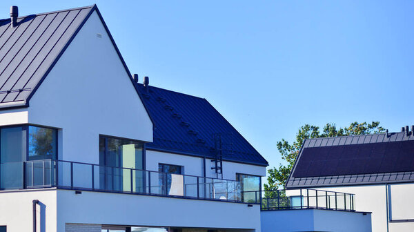 New elegant modern single family house. Terraced family homes in newly developed housing estate. Facade of a modern house with white walls. Real estate concept, european style.  