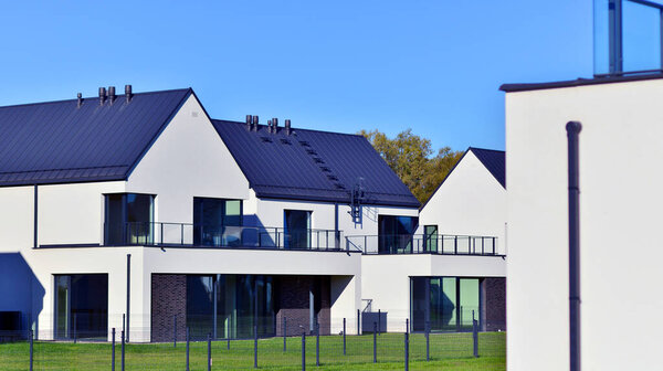 New elegant modern single family house. Terraced family homes in newly developed housing estate. Facade of a modern house with white walls. Real estate concept, european style.  