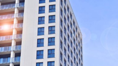 Modern high-rise apartment building  in white, stand tall against a blue sky, exemplifying innovative urban architecture with sleek, angular designs. clipart