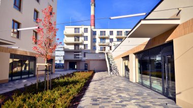 Çok katlı bina ve fabrika bacası. Yeni çok katlı cephe, pencereler ve apartman bloğu. Modern apartman kompleksi. 