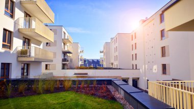 Mavi gökyüzü olan güneşli bir günde modern apartman binaları. Modern bir apartmanın ön cephesi. Gündüz gözüyle çağdaş yerleşim yerinin dış tarafında.. 