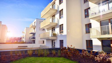 Mavi gökyüzü olan güneşli bir günde modern apartman binaları. Modern bir apartmanın ön cephesi. Gündüz gözüyle çağdaş yerleşim yerinin dış tarafında.. 