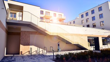 Mavi gökyüzü olan güneşli bir günde modern apartman binaları. Modern bir apartmanın ön cephesi. Gündüz gözüyle çağdaş yerleşim yerinin dış tarafında.. 