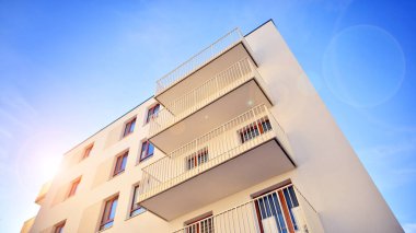 Mavi gökyüzü olan güneşli bir günde modern apartman binaları. Modern bir apartmanın ön cephesi. Gündüz gözüyle çağdaş yerleşim yerinin dış tarafında.. 