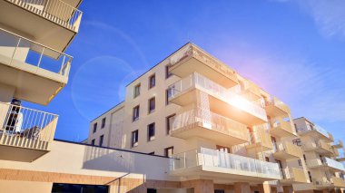 Mavi gökyüzü olan güneşli bir günde modern apartman binaları. Modern bir apartmanın ön cephesi. Gündüz gözüyle çağdaş yerleşim yerinin dış tarafında.. 
