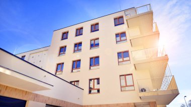 Mavi gökyüzü olan güneşli bir günde modern apartman binaları. Modern bir apartmanın ön cephesi. Gündüz gözüyle çağdaş yerleşim yerinin dış tarafında.. 