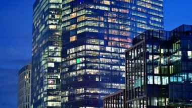 Akşamları daha aydınlık çalışma alanları olan ofis binası. Finans bölgesinde modern, parlak bir gökdelen. Ofiste geç saatlere kadar..