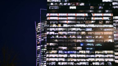 Akşamları daha aydınlık çalışma alanları olan ofis binası. Finans bölgesinde modern, parlak bir gökdelen. Ofiste geç saatlere kadar..