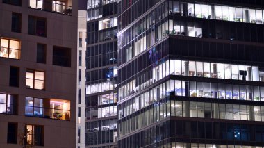 Akşamları daha aydınlık çalışma alanları olan ofis binası. Finans bölgesinde modern, parlak bir gökdelen. Ofiste geç saatlere kadar..