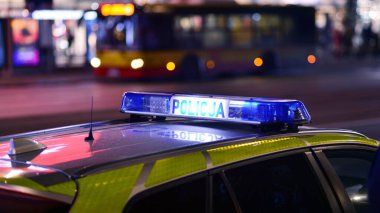 Varşova, Polonya. 22 Kasım 2024. Devriye gezen bir polis arabası ve gece sokakta mavi ışıklar..