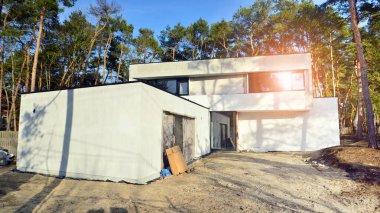 İnşaat halindeki tek bir aile evinin görüntüsü. Ormanlık alanda lüks bir ev..