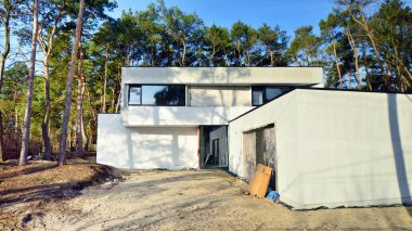 İnşaat halindeki tek bir aile evinin görüntüsü. Ormanlık alanda lüks bir ev..