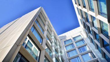 Modern bir otel binasında büyük cam pencereler. Modern şehir mimarisi. Beton duvar panellerinde geniş cam parçaları var..