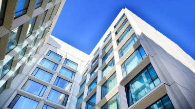 Modern bir otel binasında büyük cam pencereler. Modern şehir mimarisi. Beton duvar panellerinde geniş cam parçaları var..