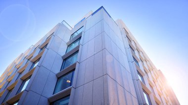 Modern bir otel binasında büyük cam pencereler. Modern şehir mimarisi. Beton duvar panellerinde geniş cam parçaları var..