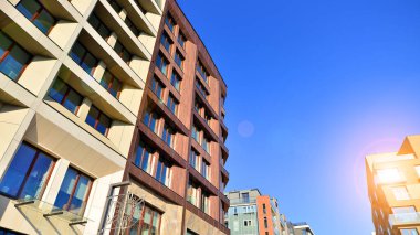 Modern Avrupa apartmanı. Mimarlık ve gayrimenkul, panoramik pencereli bir apartman. Mavi gökyüzü arka planına sahip modern kompleks.