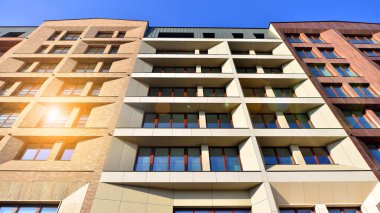 Modern Avrupa apartmanı. Mimarlık ve gayrimenkul, panoramik pencereli bir apartman. Mavi gökyüzü arka planına sahip modern kompleks.