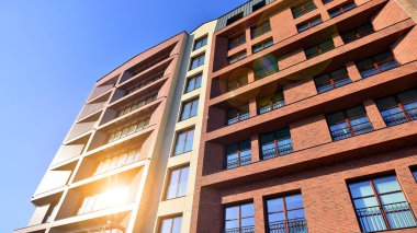 Modern Avrupa apartmanı. Mimarlık ve gayrimenkul, panoramik pencereli bir apartman. Mavi gökyüzü arka planına sahip modern kompleks.