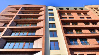 Modern Avrupa apartmanı. Mimarlık ve gayrimenkul, panoramik pencereli bir apartman. Mavi gökyüzü arka planına sahip modern kompleks.