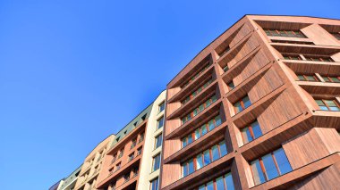 Modern Avrupa apartmanı. Mimarlık ve gayrimenkul, panoramik pencereli bir apartman. Mavi gökyüzü arka planına sahip modern kompleks.