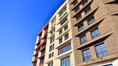 Modern Avrupa apartmanı. Mimarlık ve gayrimenkul, panoramik pencereli bir apartman. Mavi gökyüzü arka planına sahip modern kompleks.