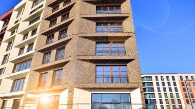 Modern Avrupa apartmanı. Mimarlık ve gayrimenkul, panoramik pencereli bir apartman. Mavi gökyüzü arka planına sahip modern kompleks.