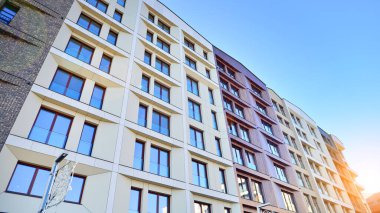 Modern Avrupa apartmanı. Mimarlık ve gayrimenkul, panoramik pencereli bir apartman. Mavi gökyüzü arka planına sahip modern kompleks.