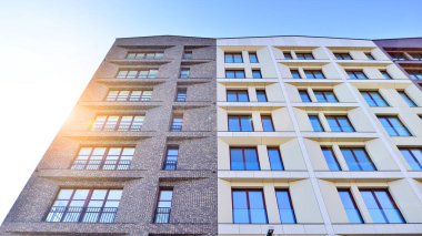 Modern Avrupa apartmanı. Mimarlık ve gayrimenkul, panoramik pencereli bir apartman. Mavi gökyüzü arka planına sahip modern kompleks.