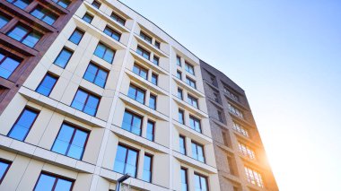 Modern Avrupa apartmanı. Mimarlık ve gayrimenkul, panoramik pencereli bir apartman. Mavi gökyüzü arka planına sahip modern kompleks.