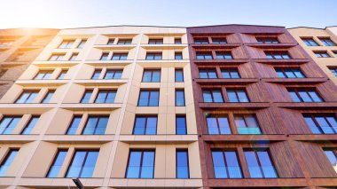 Modern Avrupa apartmanı. Mimarlık ve gayrimenkul, panoramik pencereli bir apartman. Mavi gökyüzü arka planına sahip modern kompleks.