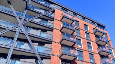 Modern Avrupa apartmanı. Mimarlık ve gayrimenkul, panoramik pencereli bir apartman. Mavi gökyüzü arka planına sahip modern kompleks.