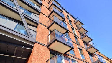 Modern Avrupa apartmanı. Mimarlık ve gayrimenkul, panoramik pencereli bir apartman. Mavi gökyüzü arka planına sahip modern kompleks.